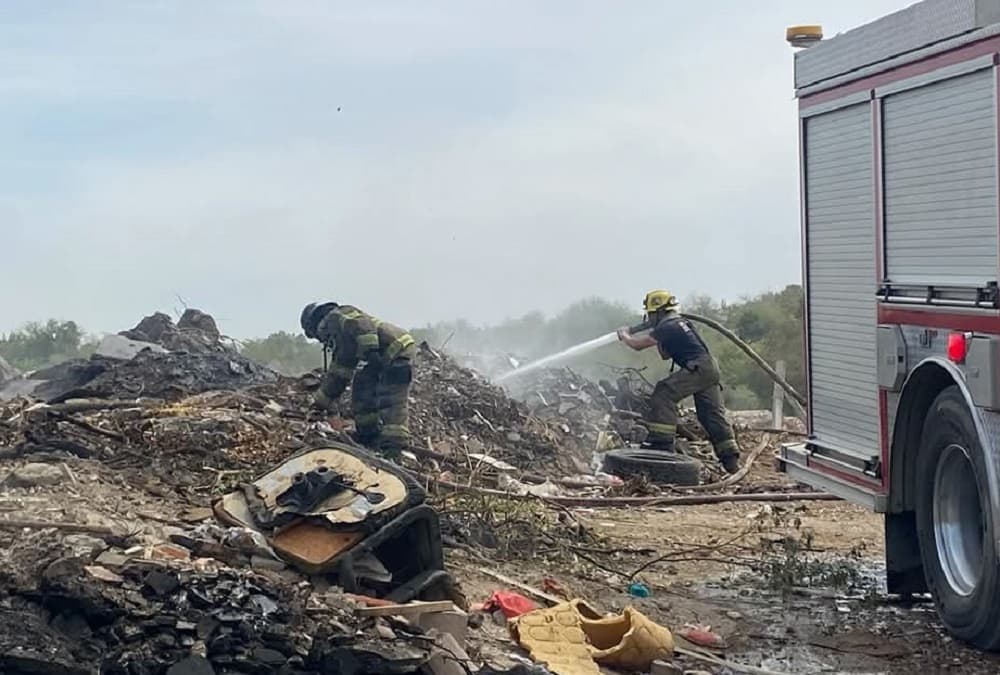 bomberos sofocando un basurero clandestino-min
